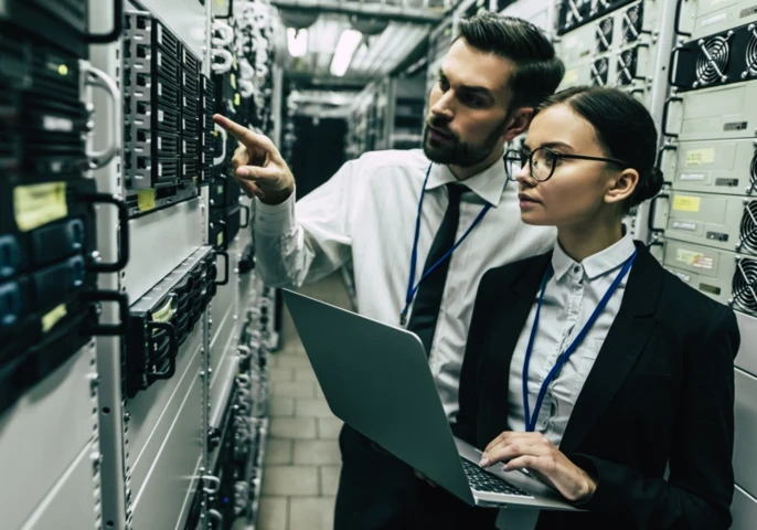 Two businesspeople standing in a server room.
