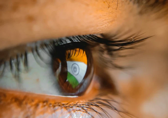 Indian flag on a computer screen reflecting in an Indian man's eye.