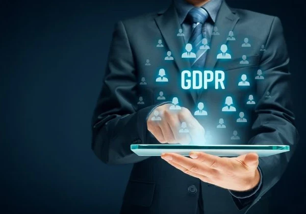 Businessman holding a tablet with the acronym "GDPR" floating above it.