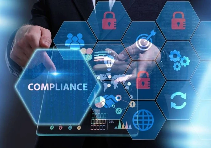 An image with the word "Compliance" and honeycomb shapes with icons in them floating around a person holding a tablet.