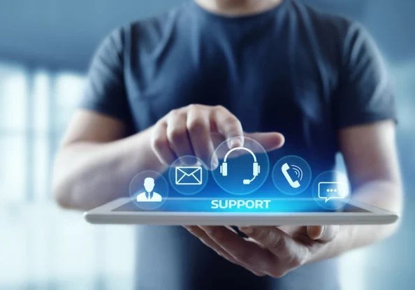 A person with a tablet pointing at the word "Support" with icons floating above.
