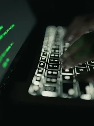Hacker working on a laptop showing a data leak