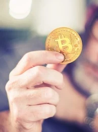 Image showing someone holding a gold Bitcoin coin