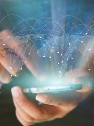 Person holding a smartphone with a see-through global map imposed on it.