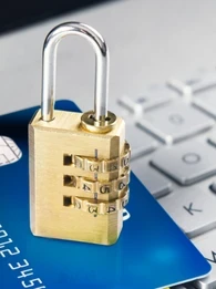 A lock sitting on top of a card that's laying on a keyboard.