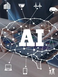 Image depicting various technology-related icons around a brain and the letters "AI" against a background of people using a tablet at a desk.