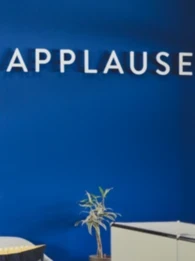 Applause logo on a dark blue wall in an office