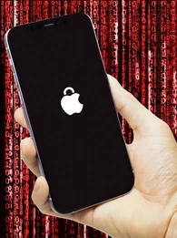 Person holding an iPhone up against a red background with binary code.