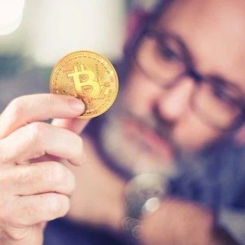 Image showing someone holding a gold Bitcoin coin