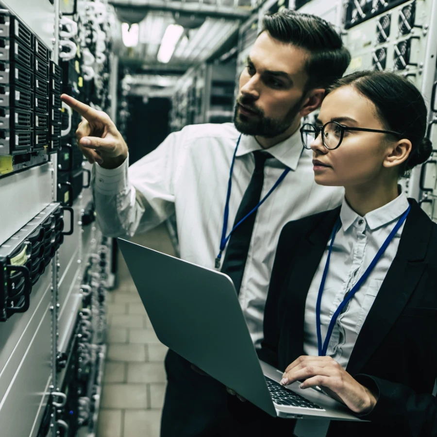 Two businesspeople standing in a server room.