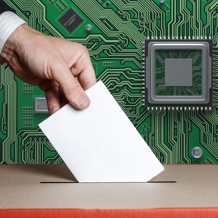 A hand placing a paper into a ballot box against a circuit board background.