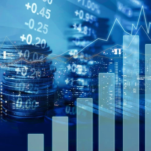 An image depicting a graph, coins and stocks.