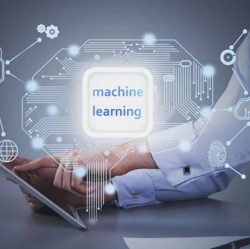 The words "machine learning" against a circuit board imagery and a person working on a tablet at a desk in the background.